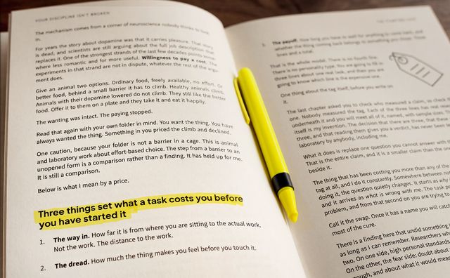 The book lying open with a yellow highlighter across the page and one heading marked.
